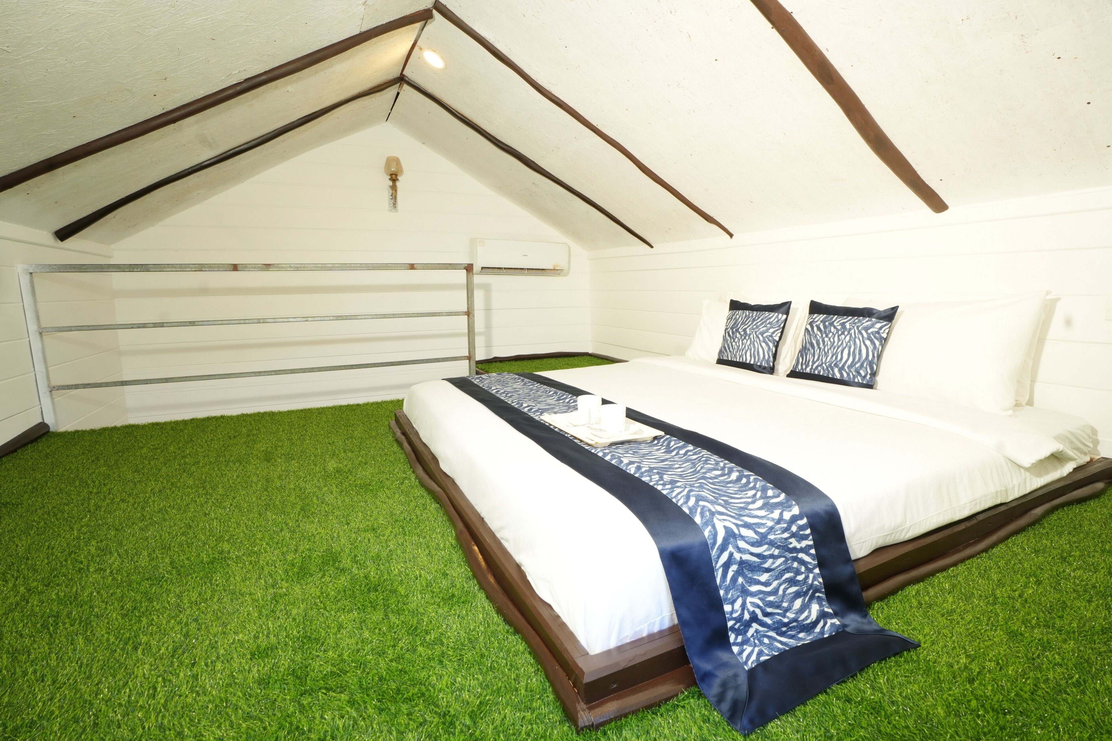 A bedroom with a bed, pillows, and a headboard.