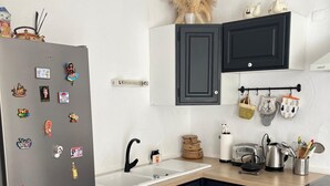 Eine Küche mit Kühlschrank, Spüle und Schränken.