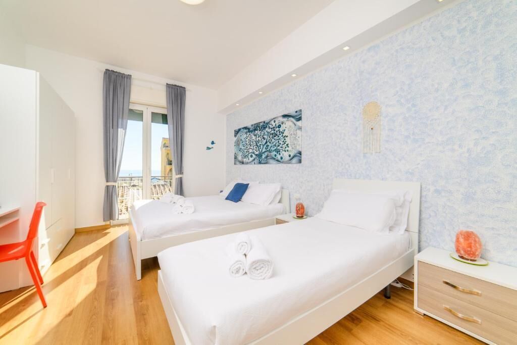 Ein Hotelzimmer mit zwei Betten, einem Schreibtisch und einem Stuhl.