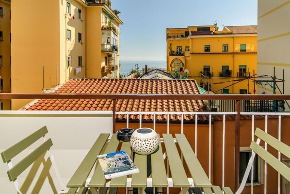 Un balcone con un tavolo, sedie e una rivista.