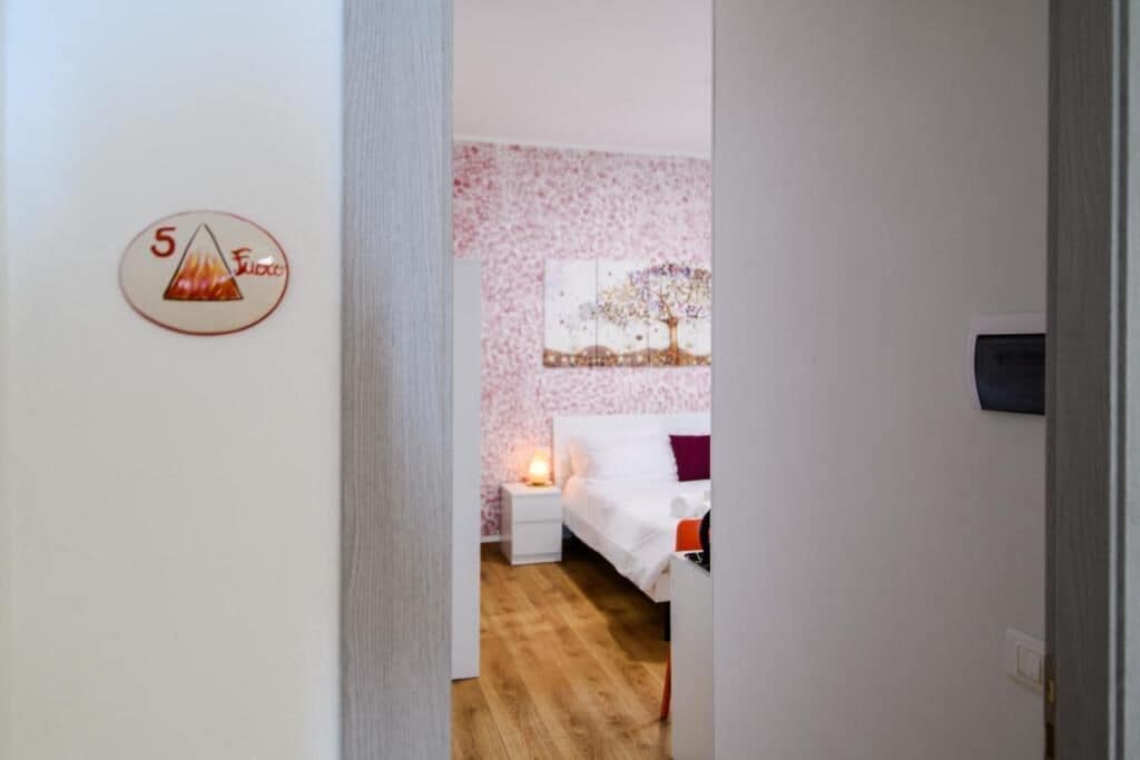 A bedroom with a bed, a nightstand, and a wall-mounted artwork.