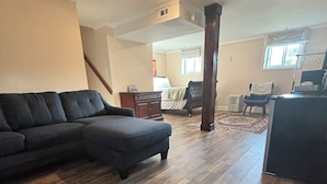 A spacious living room with a sectional sofa, a small table, and a chair.