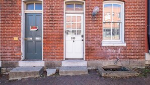 A red brick building with three doors, numbered 926, 930, and B. - Cozy Beach Apartment in Soulard (St. Louis)