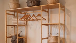 Un mueble de almacenamiento de madera con varios niveles, cestas y un perchero.