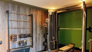A gym with a wooden wall, weight racks, and a green screen. - Flat Jacuzzi Ocean Art Park by Living (João Pessoa)