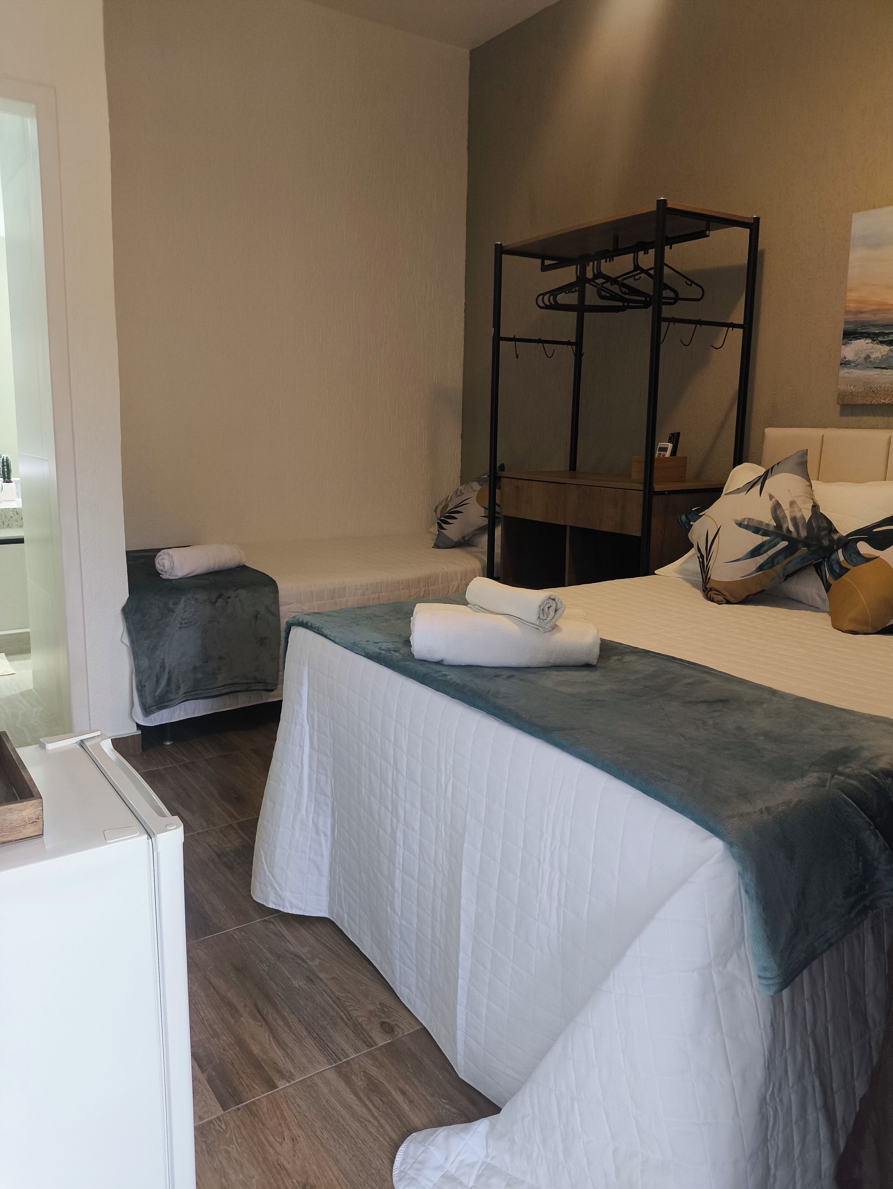 Ein Hotelzimmer mit Etagenbett, Nachttisch, kleinem Schreibtisch und Stuhl.