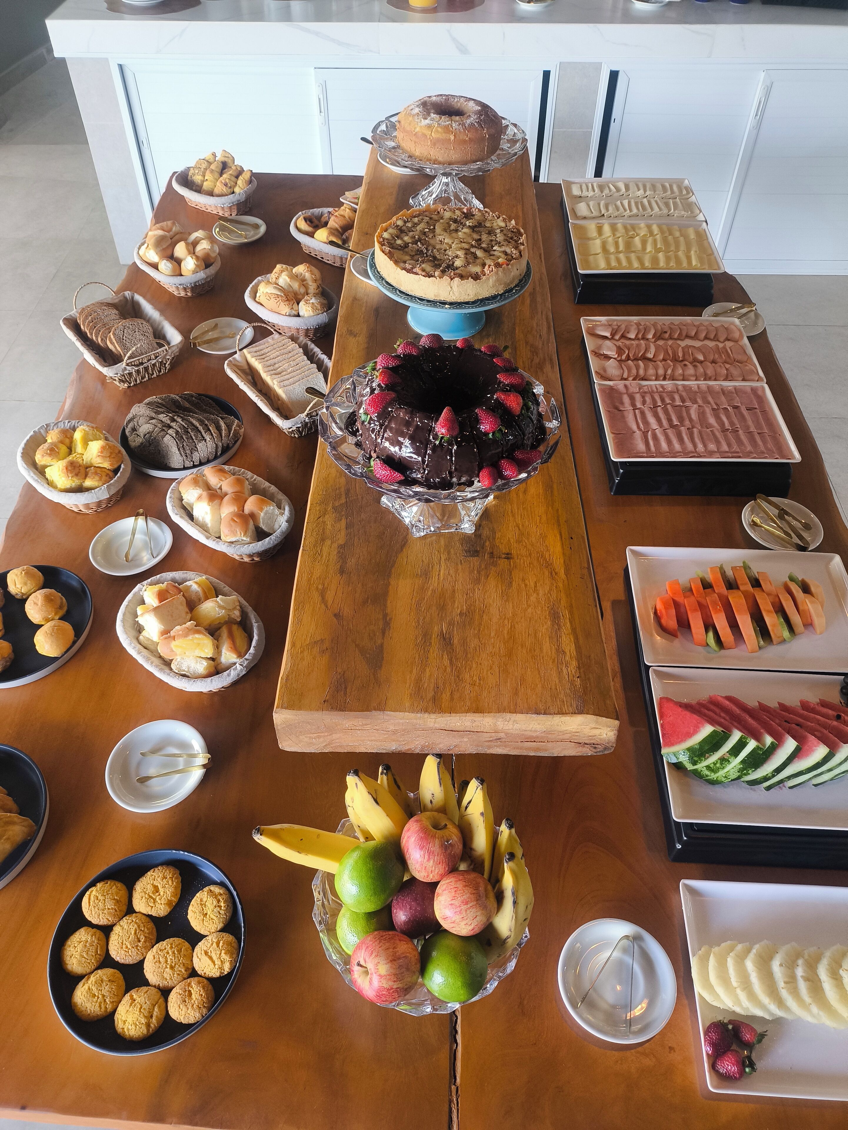 A buffet table with various food items including cakes, pastries, and fruits.