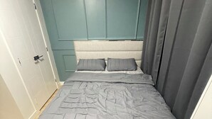 Une chambre à coucher avec un lit, un banc et une porte.
