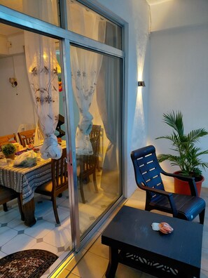 A dining area with a table set for two, a chair, and a potted plant. - Bliss, a breathtaking and budget friendly apartment in Blue Bay  (Blue Bay)