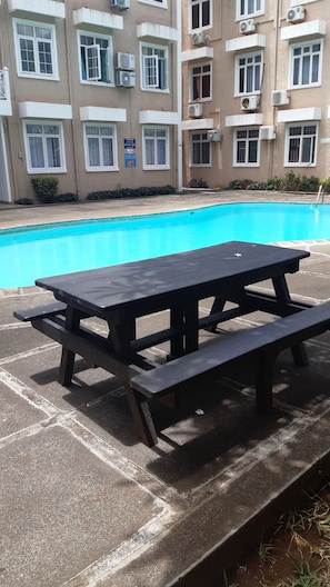 A swimming pool with a picnic table in the foreground. - Bliss, a breathtaking and budget friendly apartment in Blue Bay  (Blue Bay)