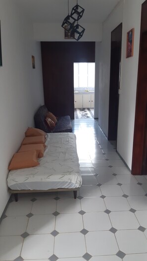 A narrow hallway with a bed at the end, a window, and a door on the right. - Bliss, a breathtaking and budget friendly apartment in Blue Bay  (Blue Bay)