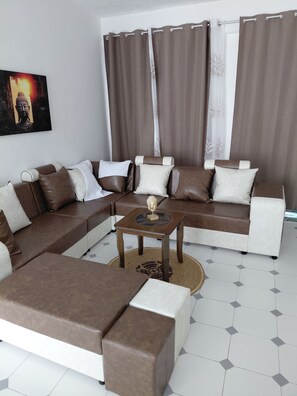 A modern living room with a sectional sofa, a coffee table, and a patterned rug.