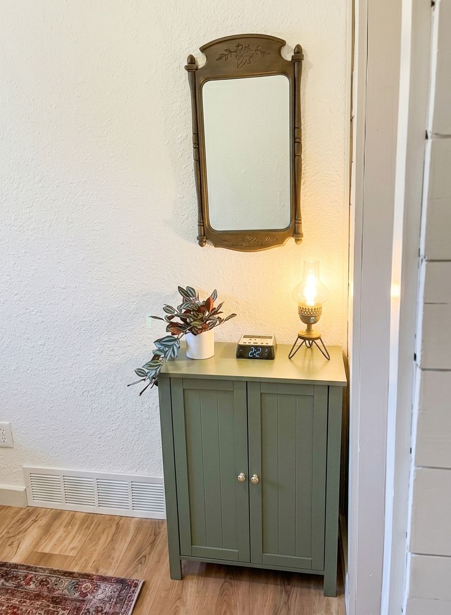 Ein grüner Schrank mit einer Uhr und einer kleinen Pflanze darauf.