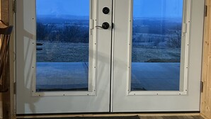 A double door with a view of a snowy landscape. - Charming Cabin - Wake up to the Epic Views, Stay for the Convenience (Carlisle)