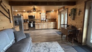 A modern log cabin interior with a living room, kitchen, and dining area. - Charming Cabin - Wake up to the Epic Views, Stay for the Convenience (Carlisle)