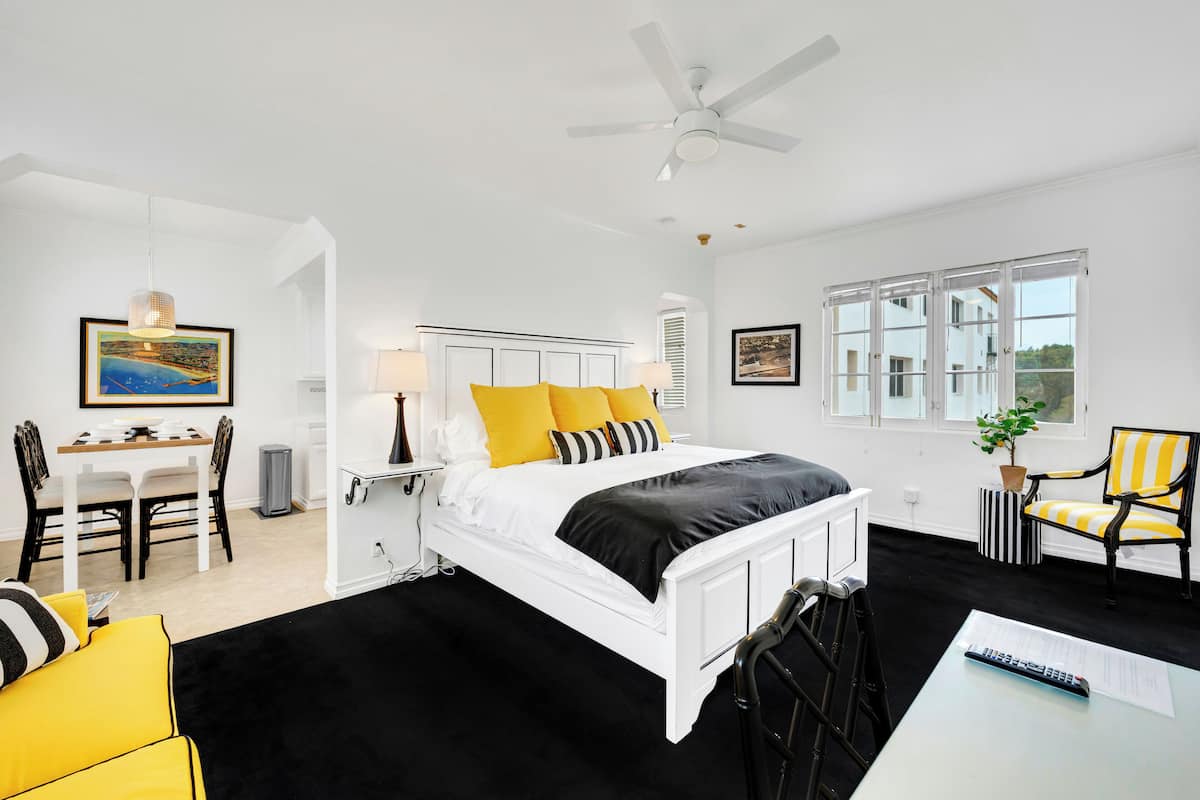Una habitación de hotel moderna con una cama grande, un escritorio y una zona de comedor.