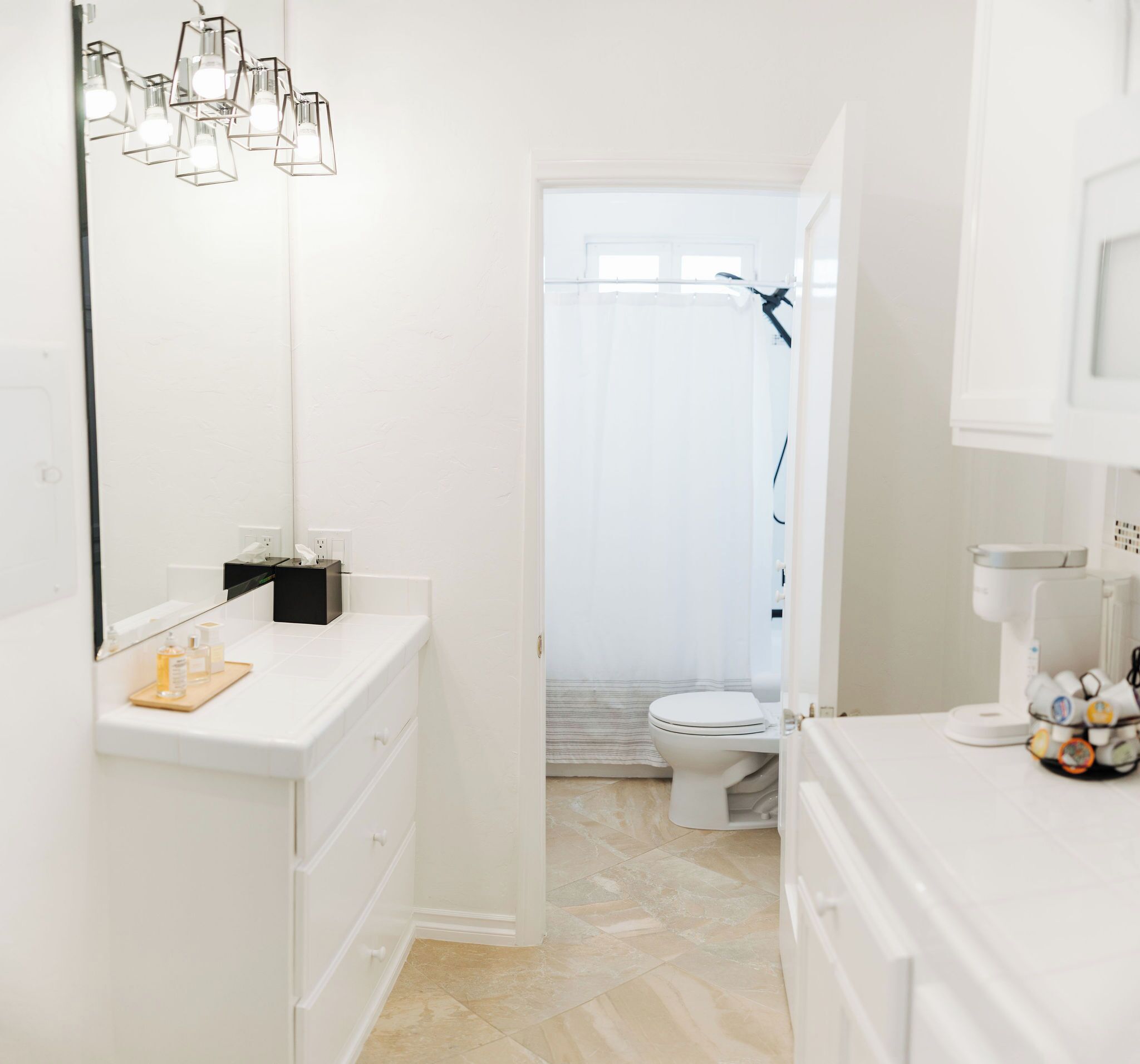 A modern bathroom with a white vanity, a shower area, and a toilet.