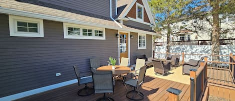 A deck with outdoor furniture, a table, and chairs.