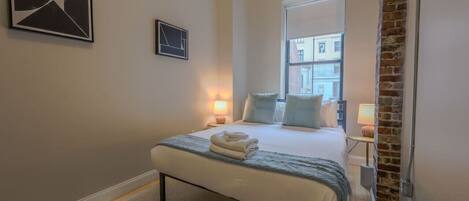 Escritorio, tabla de planchar con plancha, wifi y ropa de cama