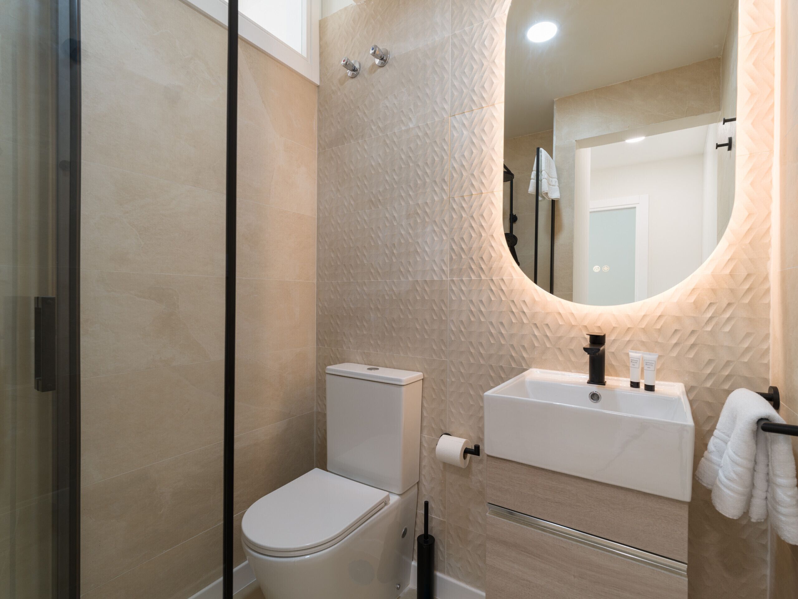 Ein modernes Badezimmer mit Toilette, Waschbecken und Dusche.