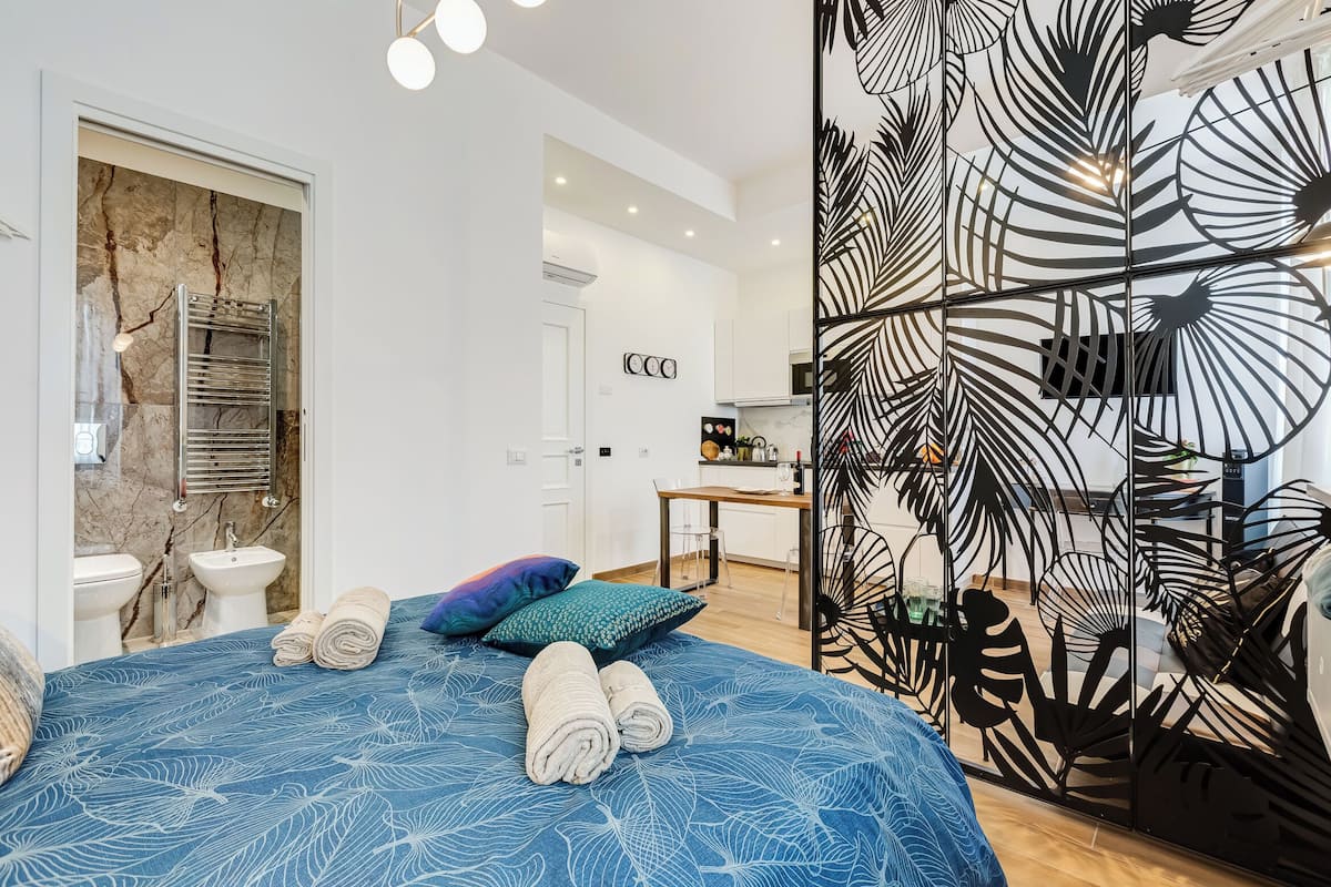 Una habitación de hotel moderna con cama, baño y zona de cocina.