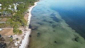 An aerial view of a coastal area with a sandy beach, clear water, and dense greenery. - Firefly South: 3,800 sqft - Sleeps 16! 2-min walk to pool and beach! (Saint Teresa)