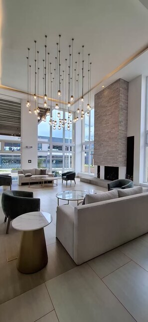 Een moderne woonkamer met een grote witte bank, een ronde salontafel en een open haard.