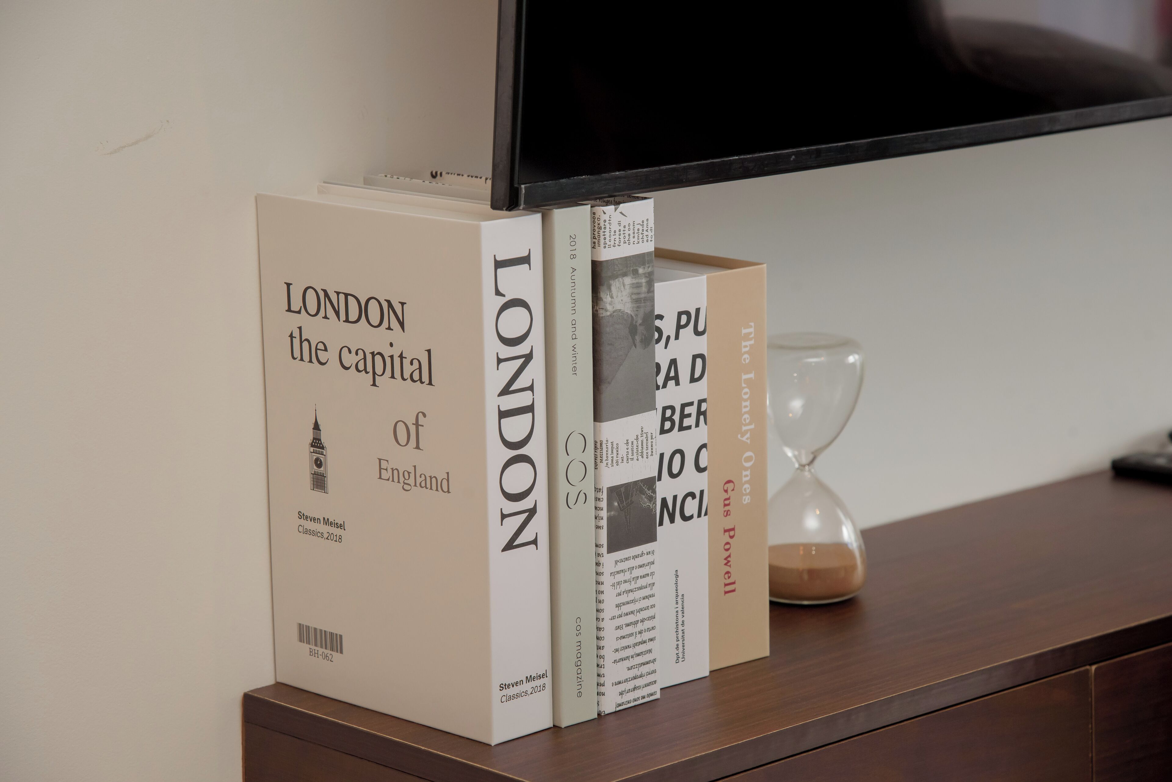 A bookshelf with books and an hourglass.