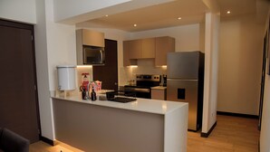 A modern kitchen with a central island, built-in appliances, and a clean, minimalist design. - Glam | Modern apartment in exclusive area of Xela (Quetzaltenango)