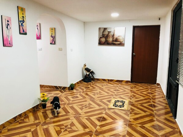 A room with patterned flooring, a door, and wall-mounted artwork.