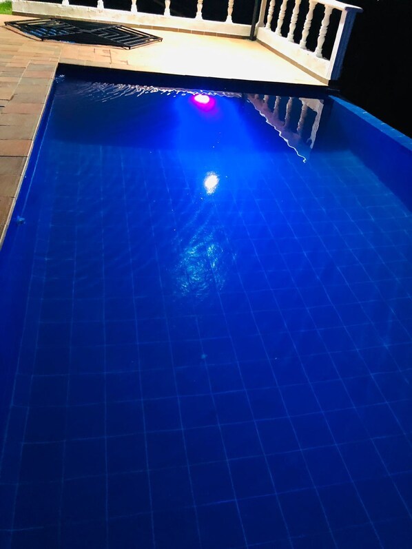 A swimming pool with a tiled floor and a light fixture above.