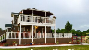 Ein zweistöckiges Wohnmobil-Resortgebäude mit Balkon, Außenbereich zum Sitzen und einem Spielplatz.