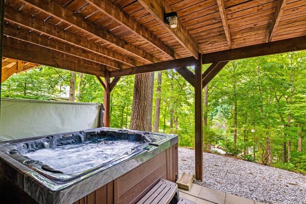 A hot tub under a wooden pergola with a forest backdrop. - Lakefront - Norris Lake - Hot Tub, 2 Slip Covered Dock, Kayaks, ATV trails (Jacksboro)