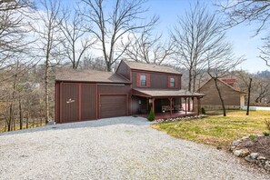 A two-story house with a covered porch and a garage.