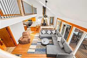 A spacious loft with a dining area, a sofa set, and a kitchen visible through an open floor plan.