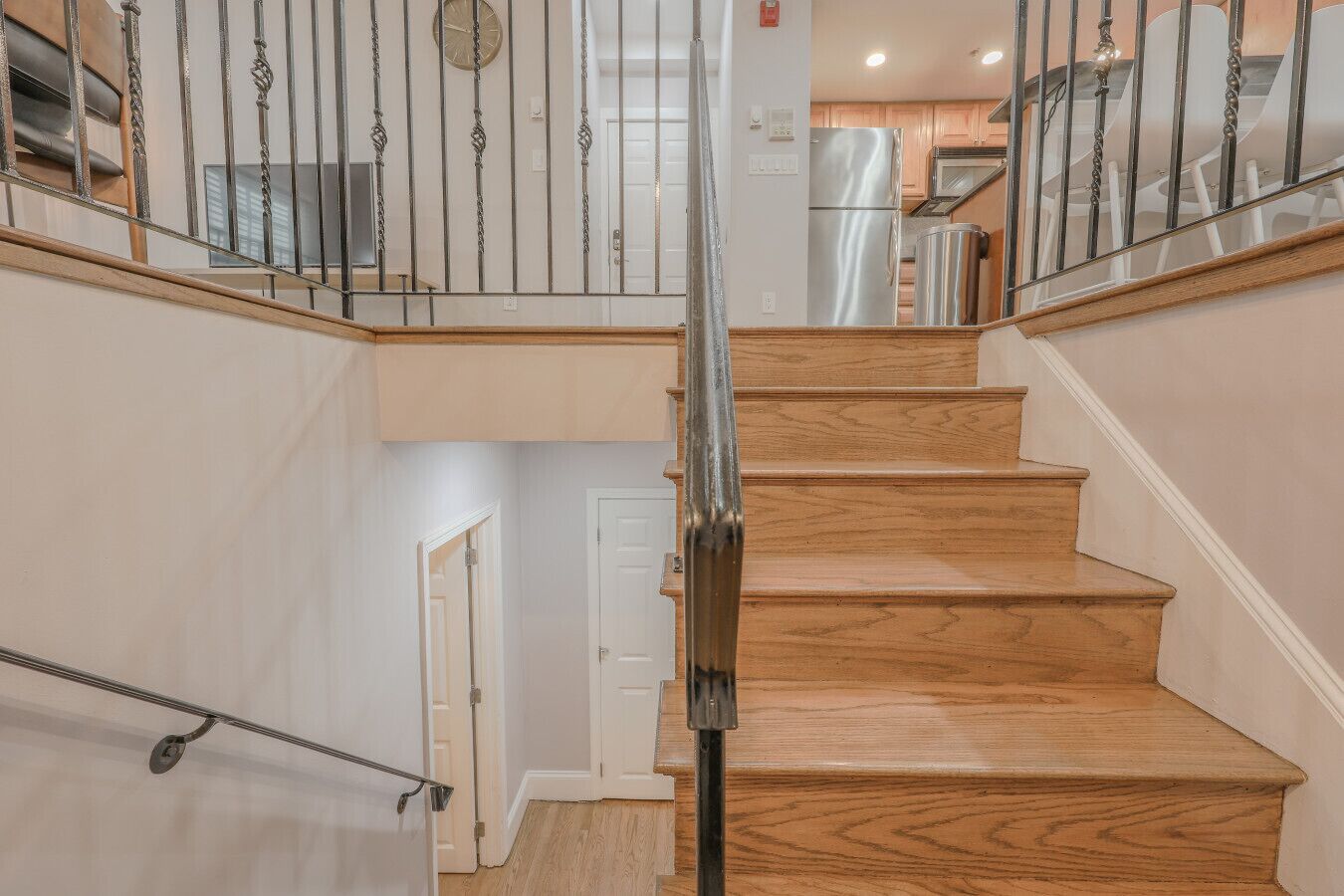 A wooden staircase with metal railings leading to an upper floor.