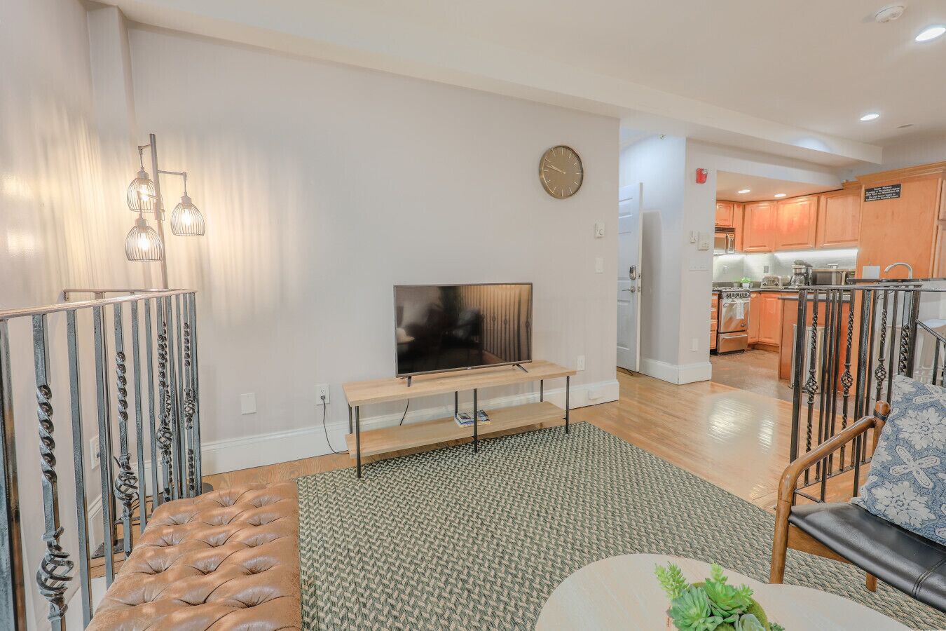 Una sala moderna con televisor, sofá y comedor con mesa y sillas.