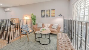 A modern living room with a sofa, armchair, coffee table, and decorative plants. - Perfect Traveling Nurse Housing - Theatre District (Boston)