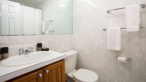 Une salle de bain moderne avec un lavabo, un meuble-lavabo et des toilettes, le tout de couleur blanche.