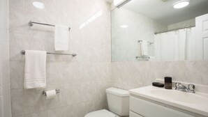 A modern bathroom with a toilet, sink, and mirror.
