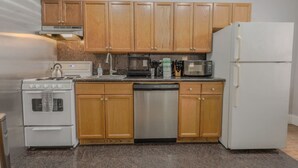 A kitchen with wooden cabinets, a stainless steel stove, a microwave, and a dishwasher.