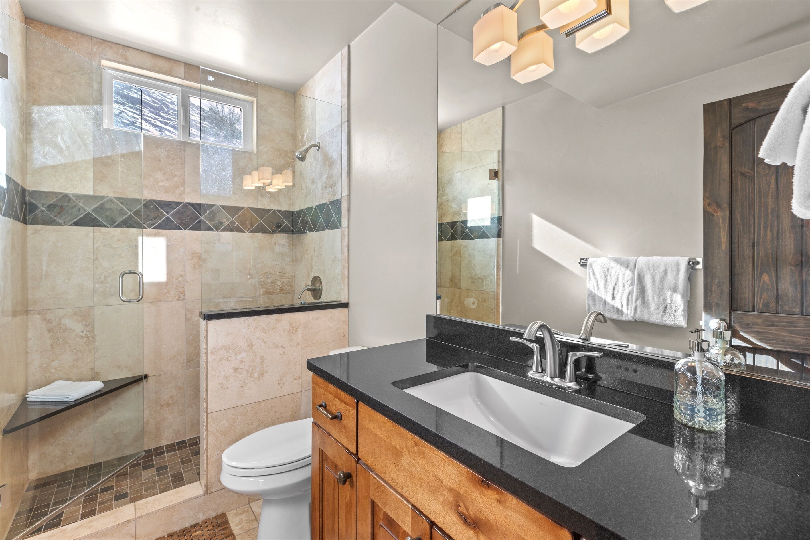 Un baño moderno con un espejo grande, un lavabo y una zona de ducha.