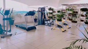 Una palestra con attrezzature per esercizi, tapis roulant e cyclette.