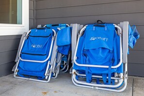 Zwei blaue Elektrorollstühle mit 'Ocean'-Branding, vor einem Gebäude mit grauen Verkleidungen geparkt.