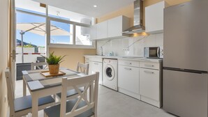 Eine moderne Küche mit Waschmaschine, Mikrowelle und Kühlschrank.