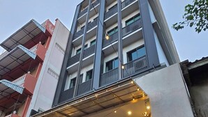 Un edificio moderno con un número de calle, un acceso cubierto y un escaparate visible.