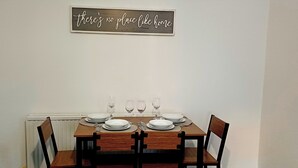 A dining table set with plates, glasses, and cutlery. - Prime Town Centre-Location-Station-Airport-WiFi-Parking (Luton)