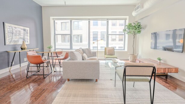 A modern living room with a sofa, chairs, a coffee table, and a TV. - Milk153-3D-2/2 · 2br/2ba FIDI Apt | Keyless Entry | Walk anywhere! (Boston)