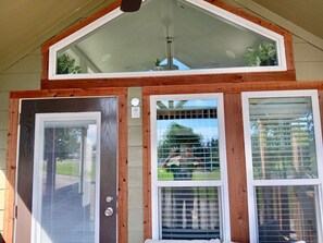 A wooden-framed entrance with three windows, each with blinds. - Discover The Green Room in Farmersville, Texas! Tiny home getaway. (Farmersville)