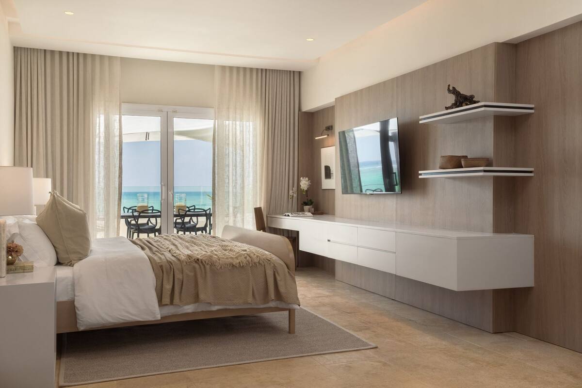 Habitació d'hotel moderna amb llit, escriptori, televisió i vista a l'oceà.